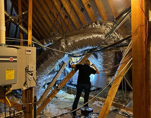 homewatcher inspecting air conditioner in  attic